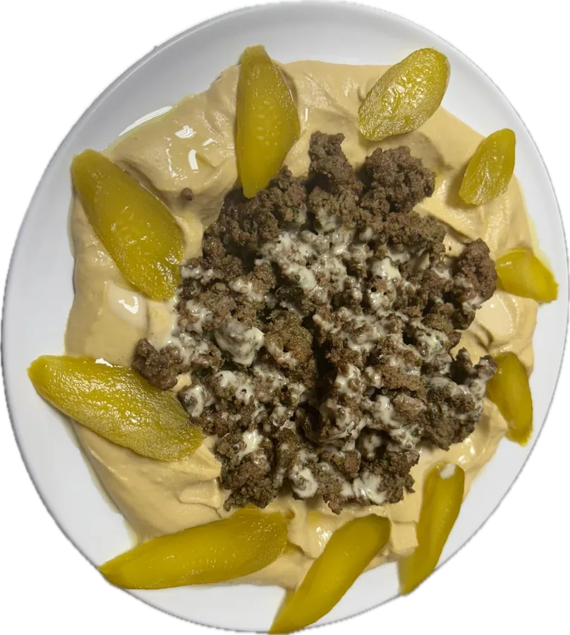 Hummus topped with seasoned ground beef, tahini and pickles